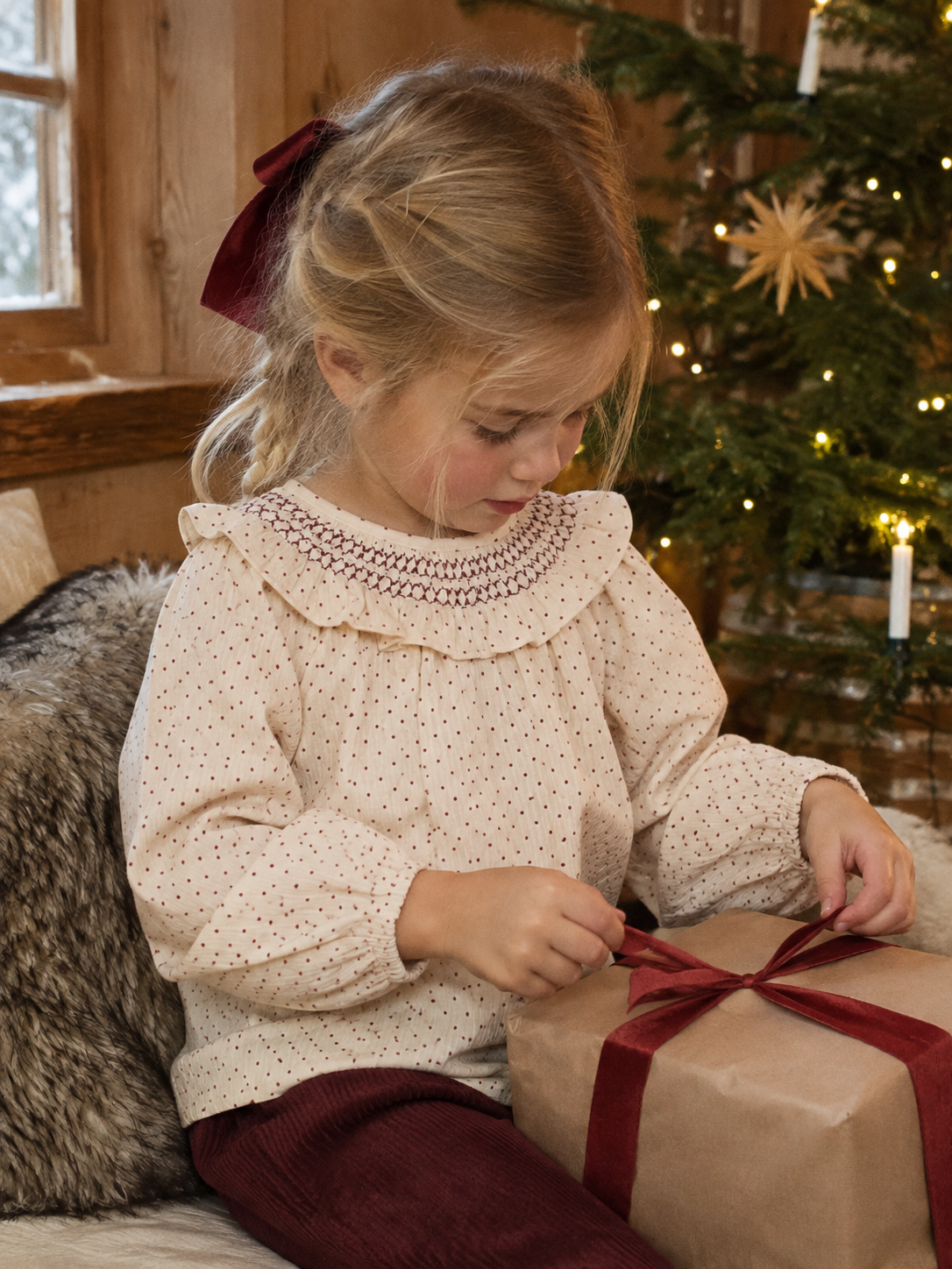 Jente i Lil Atelier Froa prikkete bluse med smock-krage pakker inn julegave