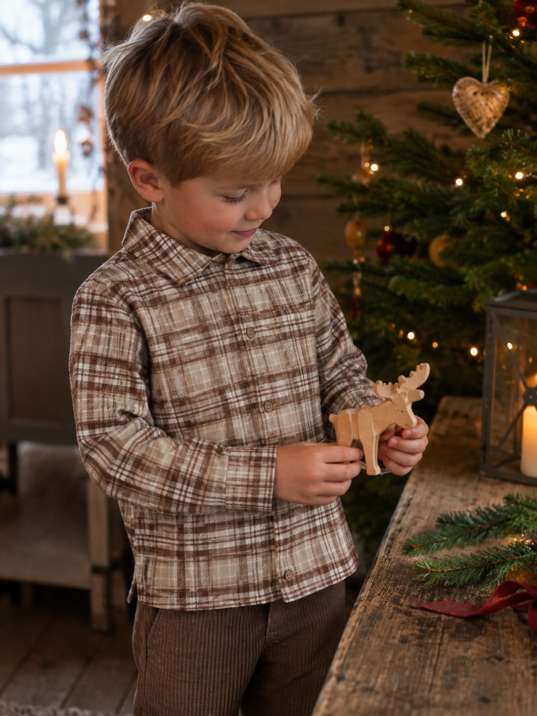 Gutt i rutete Lil Atelier Renrik skjorte ved juletreet i gårdshus