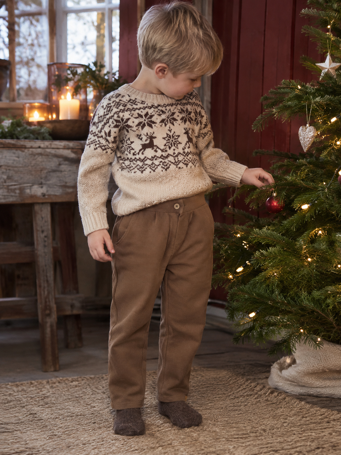 Gutt i brun Lil Atelier Kaleo bukse ved juletreet i gårdshus